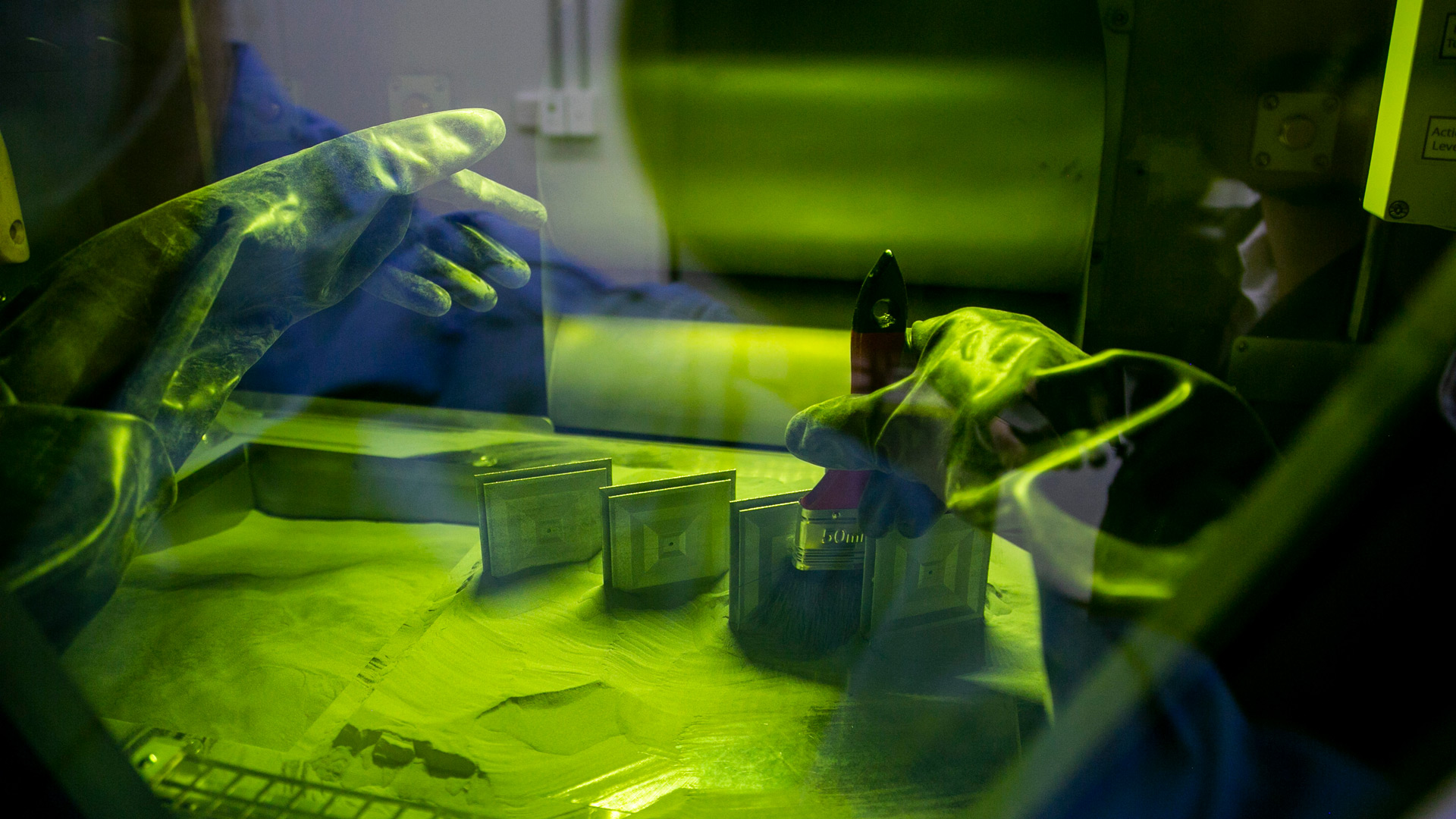 Fleet Space staff brushing freshly printed metal patch antennae